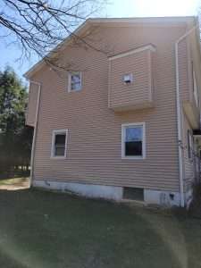 Photo of vinyl siding of house with mildew and algae after a whole house wash by Hydro Eco Clean