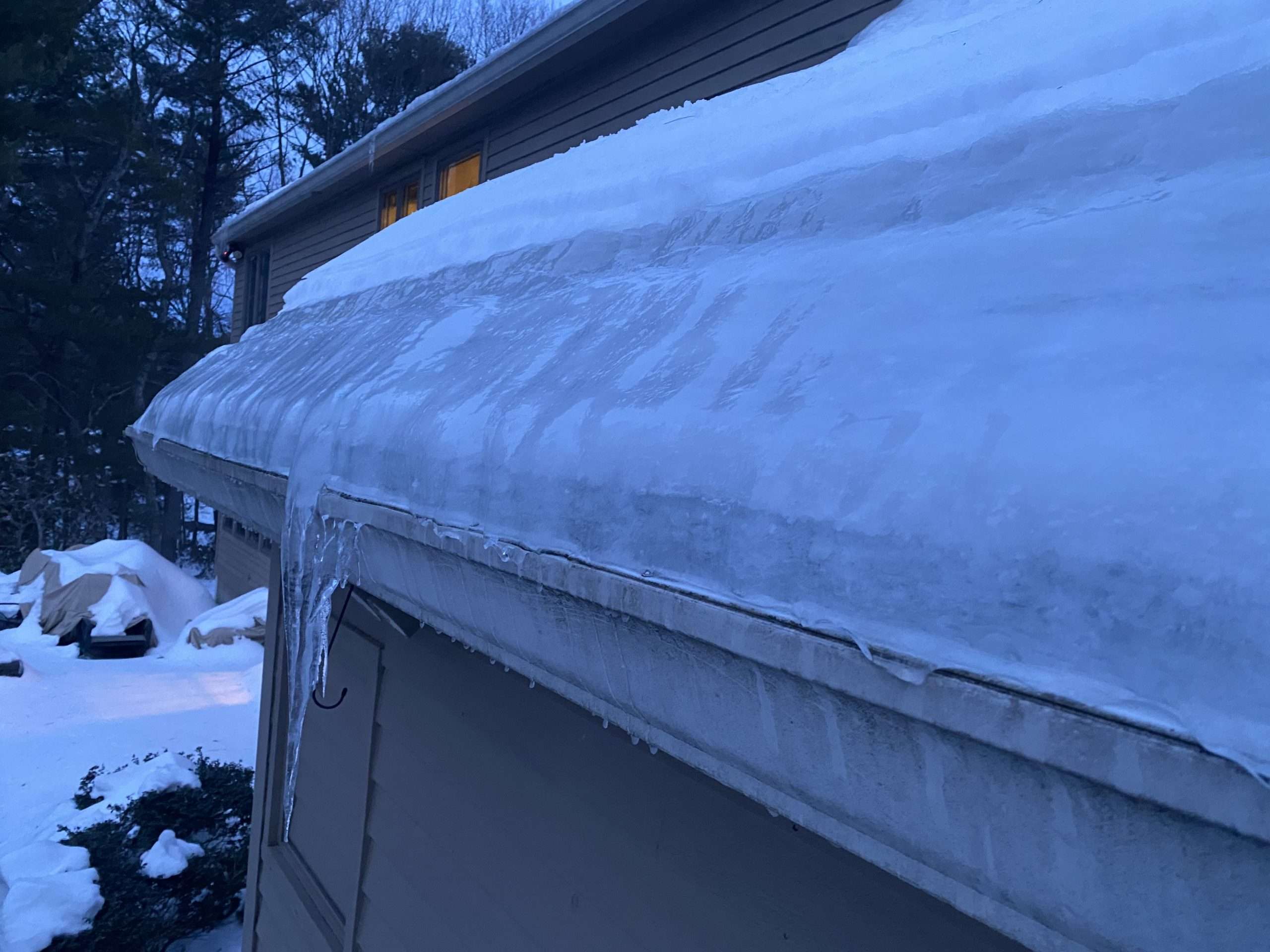 Thick ice dam buildup along the edge of a residential roof