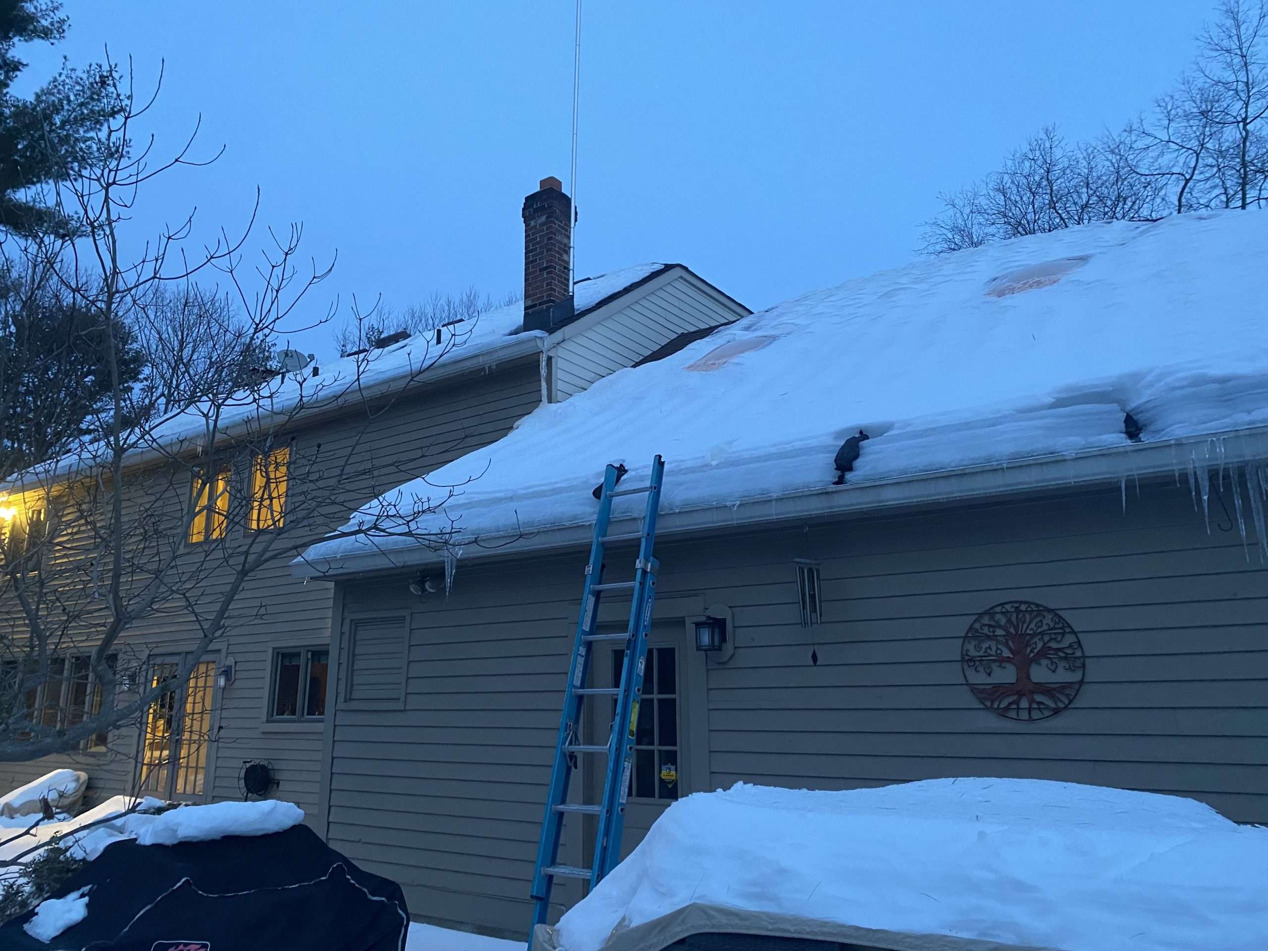 Snow-covered New Jersey home with ice buildup and icicles along the roofline